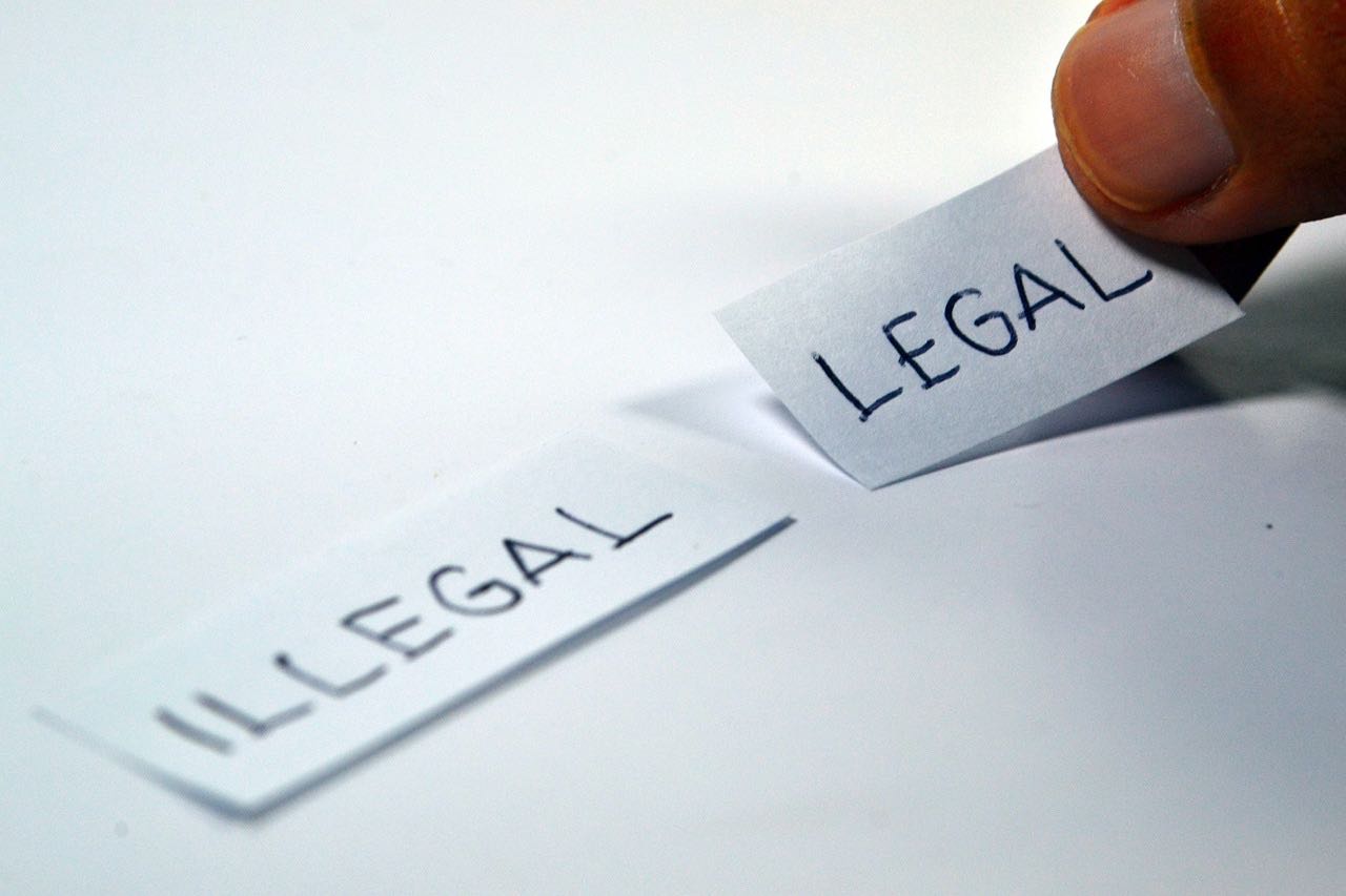 Image of someone choosing the words "illegal" or "legal"